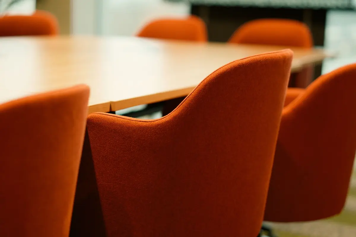 Orange upholstered chairs around a boardroom table